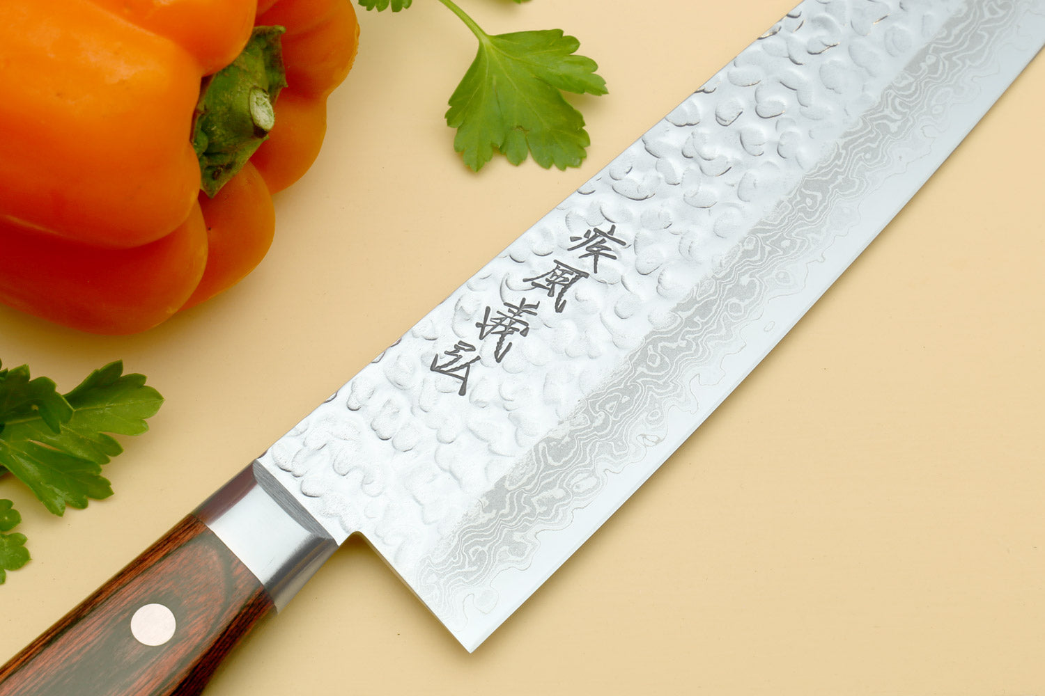 Damascus gyuto chef knife close-up, hammered silver blade with etched characters
