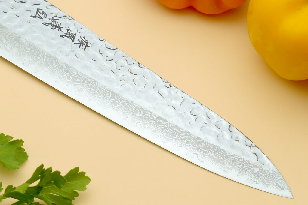 Damascus gyuto chef knife blade close-up with hammered silver pattern