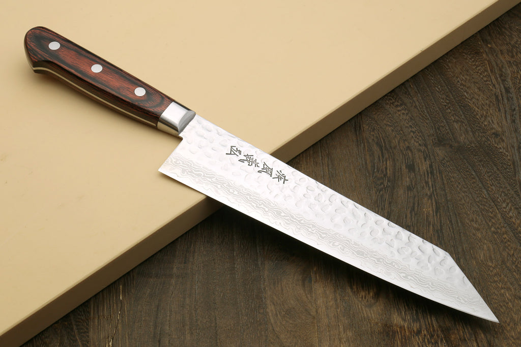 Kiritsuke multipurpose knife angled view with hammered Damascus blade and dark handle