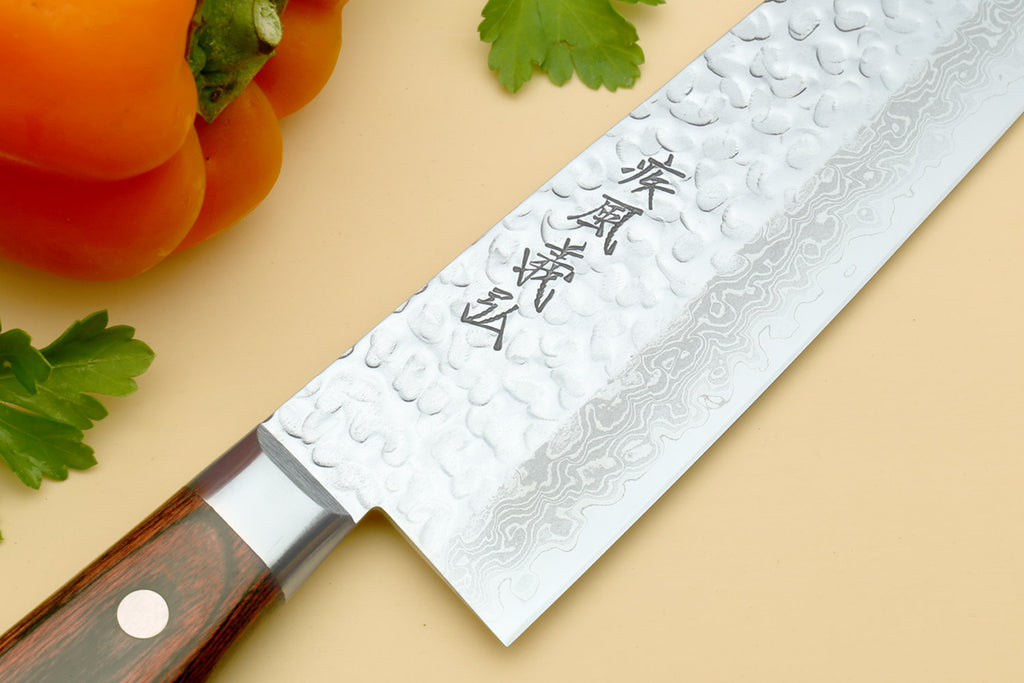 Nakiri vegetable knife close-up with hammered Damascus-style blade and dark wood handle