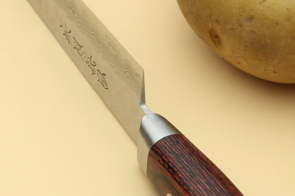 Petty knife blade close-up with etched damascus pattern and dark wood handle