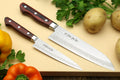 Damascus-pattern santoku knife with dark wood handle and silver bolster
