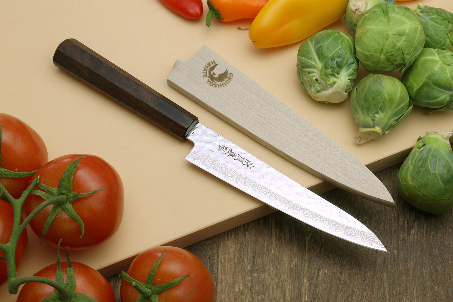 Petty knife with hammered Damascus blade, rosewood handle, and wood sheath