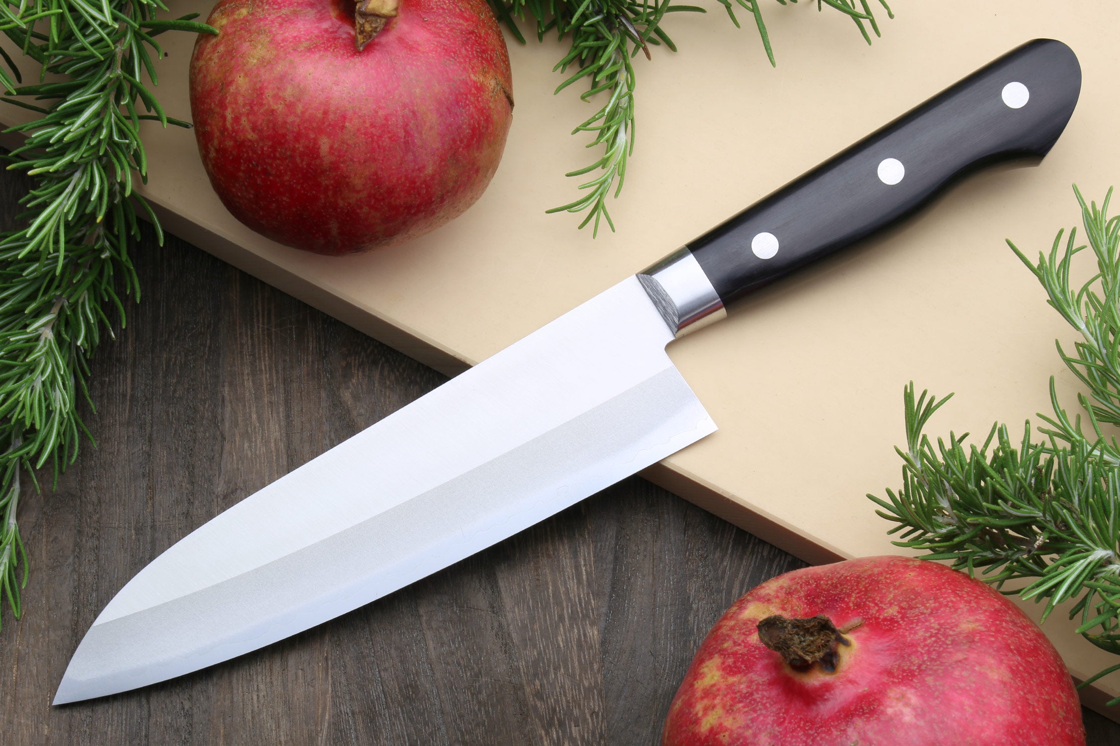 Santoku chef knife with dark handle, silver blade, and metal bolster