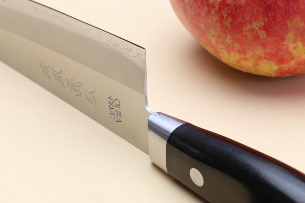 Santoku chef knife close-up: silver blade with etched text, dark handle