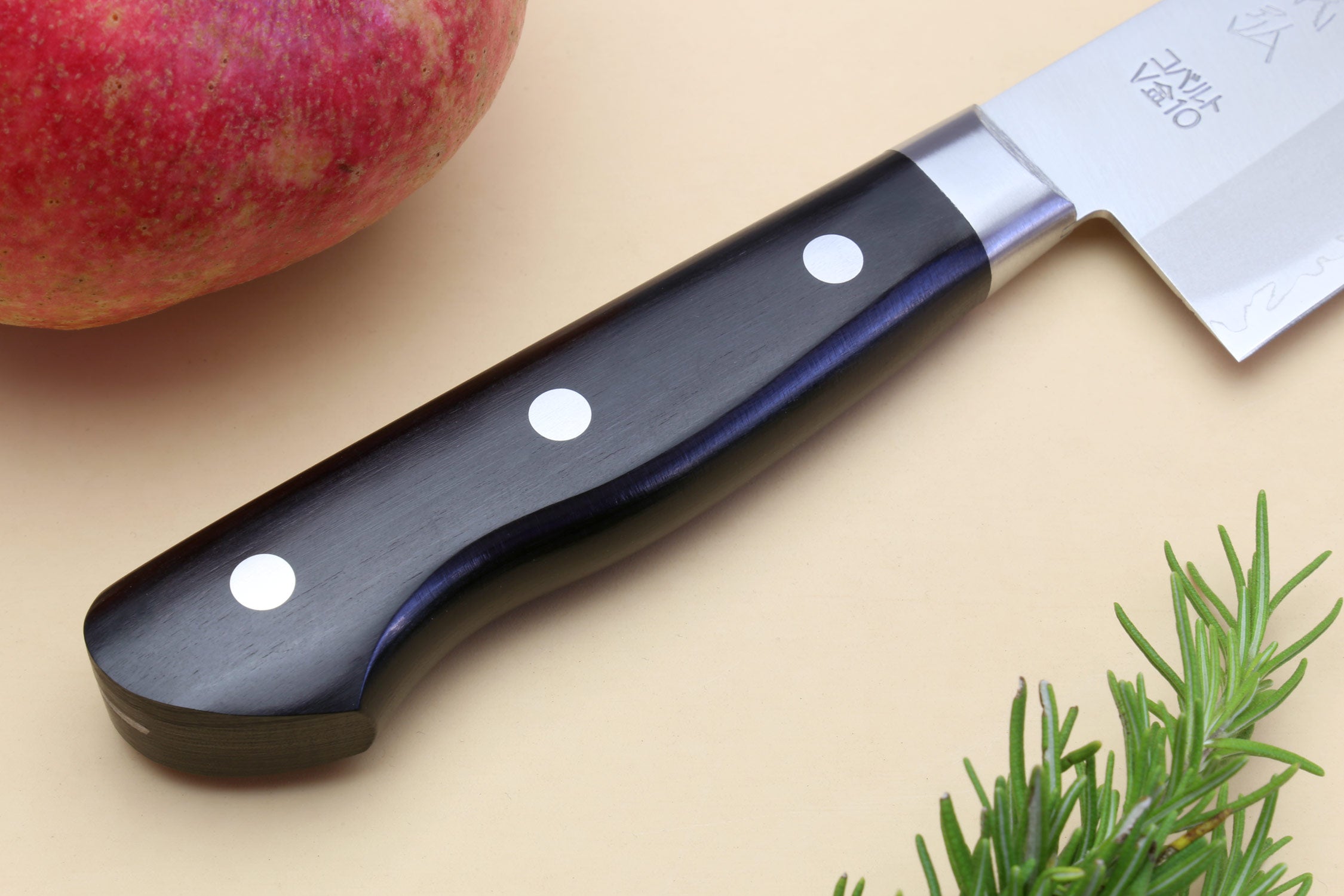 Santoku chef knife handle with dark grip, white rivet dots, and silver bolster